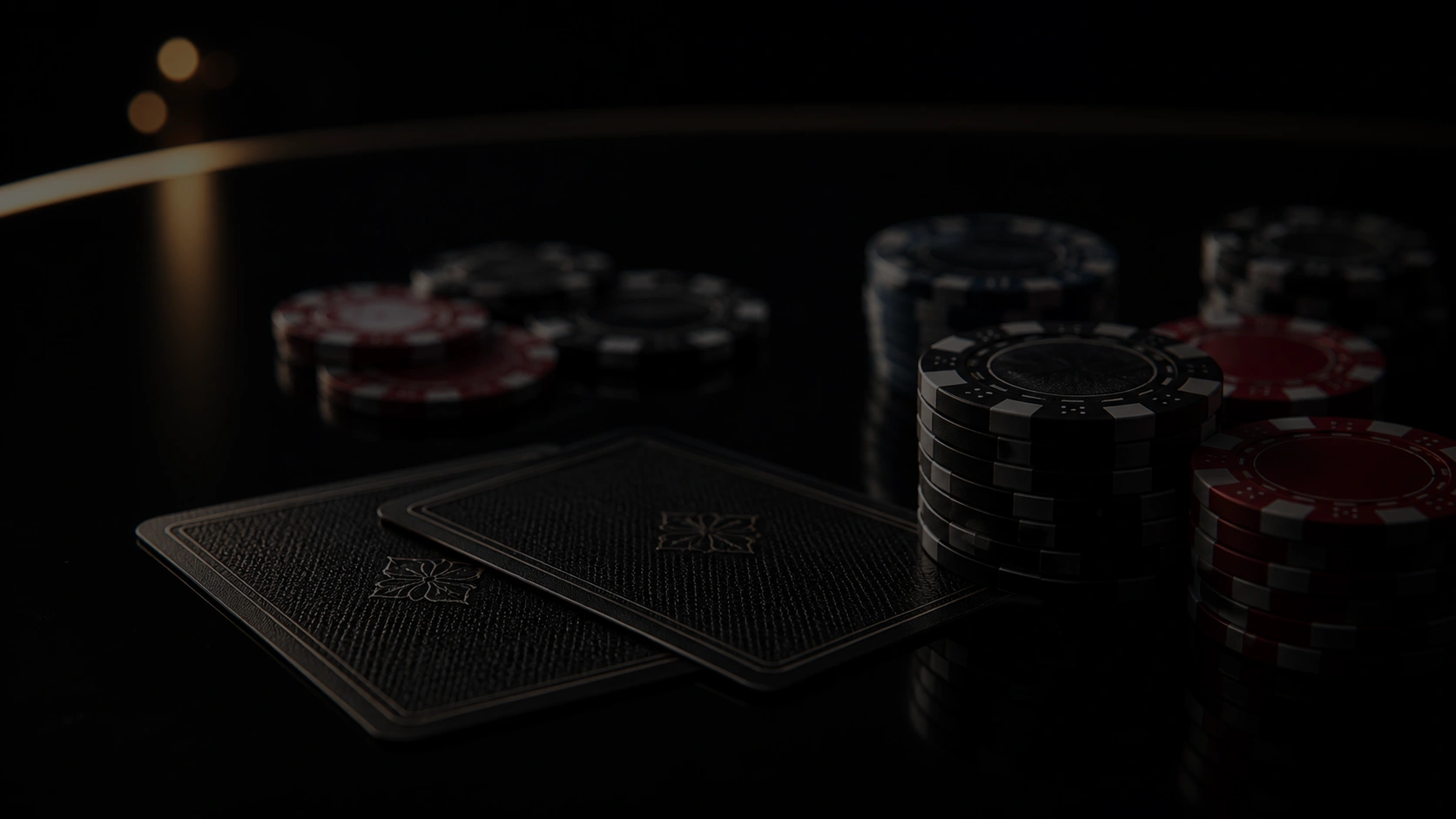 Dark casino table with stacked chips and face down cards in cinematic low light poker scene
